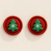 Aretes navideños de árbol verde con fondo rojo